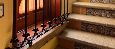 A staircase with ornate metal railings and patterned tile steps.