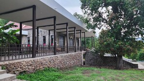 A covered outdoor area with stone walls and a metal fence. - Hotel Casa La Gran Senora (Tequila)