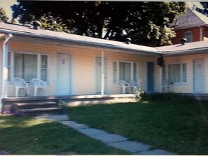 A two-story motel with a covered porch and a small front yard.