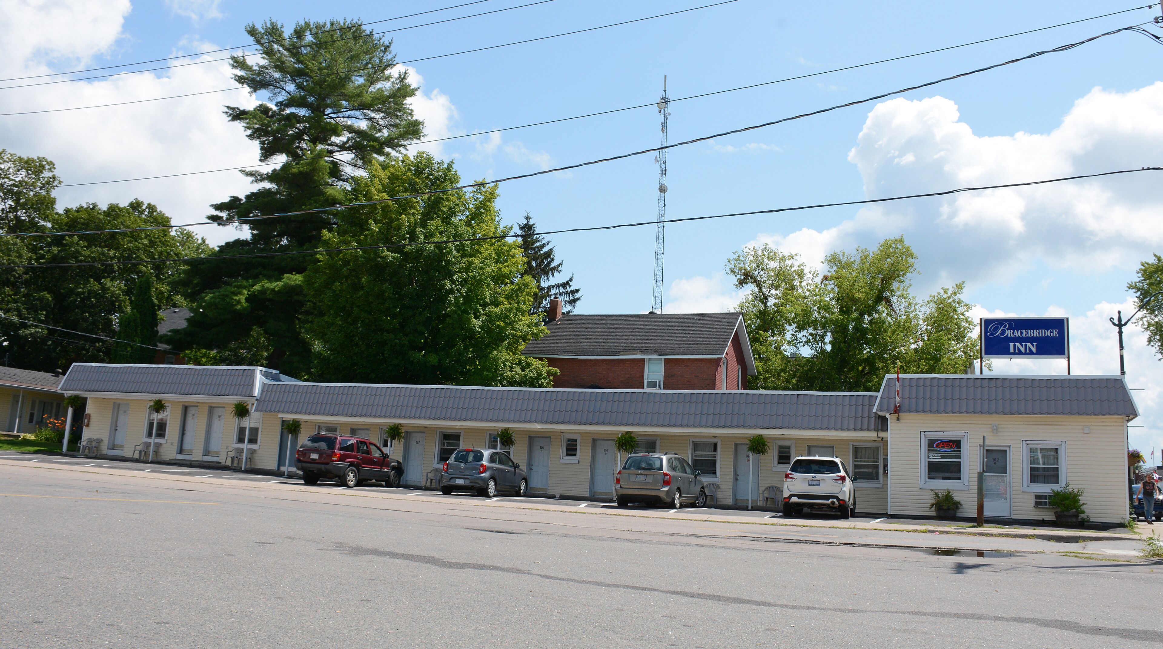 Un motel con varias habitaciones, un estacionamiento y un letrero que dice Bracebridge Inn.