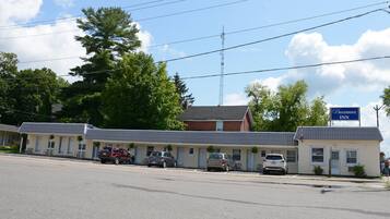 Un motel con varias habitaciones, un estacionamiento y un letrero que dice Bracebridge Inn.