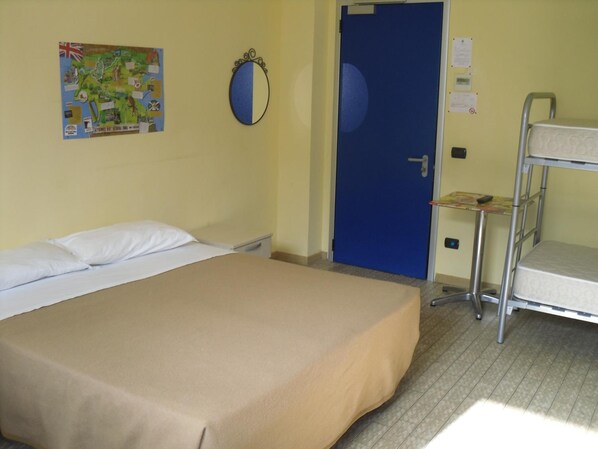 Una habitación de hotel con una cama individual, una cama litera, un mapa en la pared y una puerta azul.