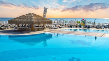 Una piscina al aire libre de temporada, sombrillas