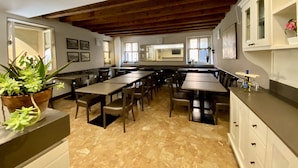 A spacious dining area with high ceilings and exposed beams, featuring multiple tables and chairs. - Hotel Aurora (Verona)