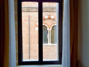 A window with a view of a brick building with arched windows and columns. - Hotel Aurora (Verona)