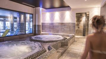 Relax in our serene spa area featuring two large hot tubs and a shower area.