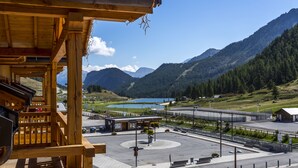 A wooden building with a view of a mountainous landscape, a parking area, and a small building labeled "Gare Routière." - CGH Résidences Boutique Le Napoléon (Montgenevre)
