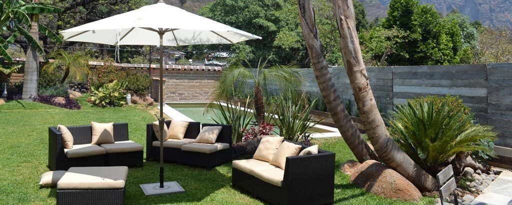 A patio with outdoor furniture, a pool, and a view of the mountains.