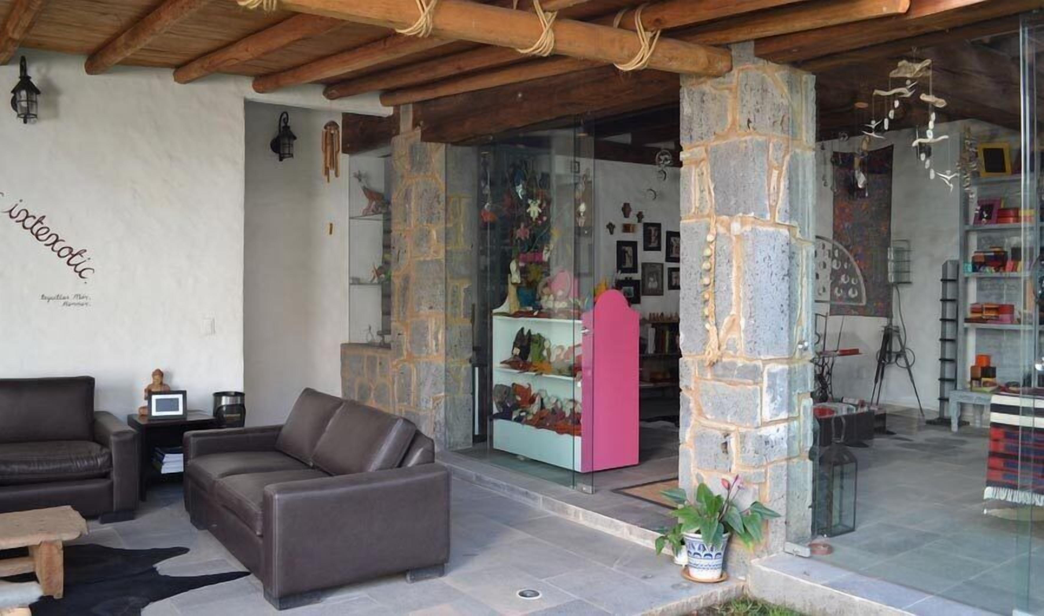 A cozy interior with a stone pillar, leather sofa, and a glass display case with shoes.