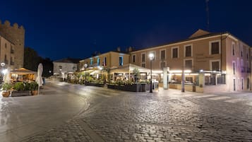 Ein Kopfsteinpflasterplatz mit Außenbestuhlung in Cafés, historischen Gebäuden und einem Fahnenmast.