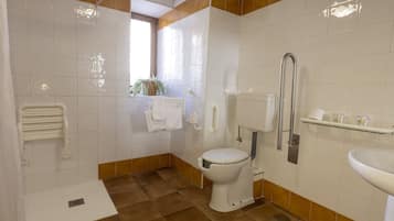 Un baño con inodoro, lavamanos, ducha y toallero.
