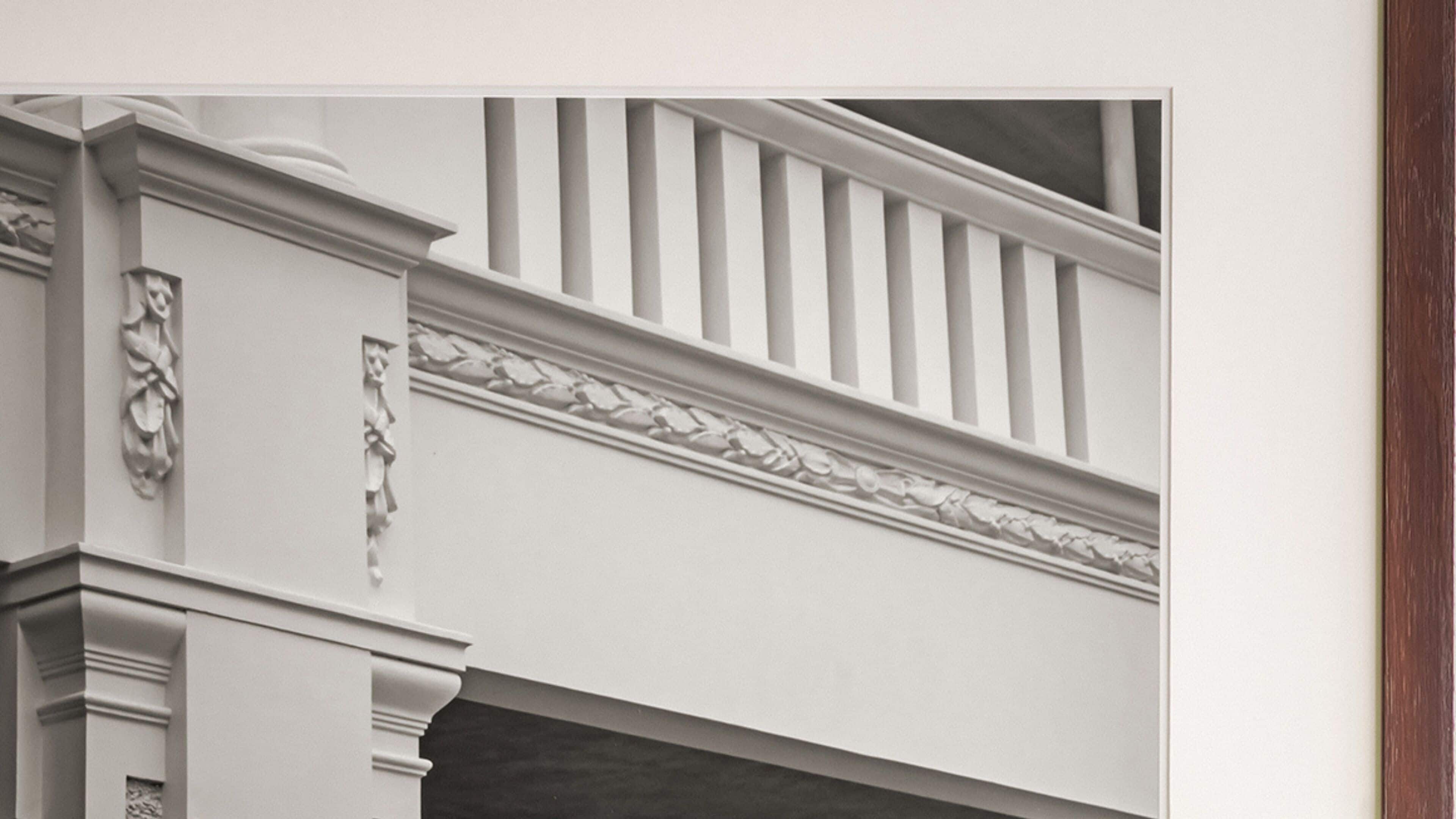 A white building facade with a decorative cornice and a balustrade.