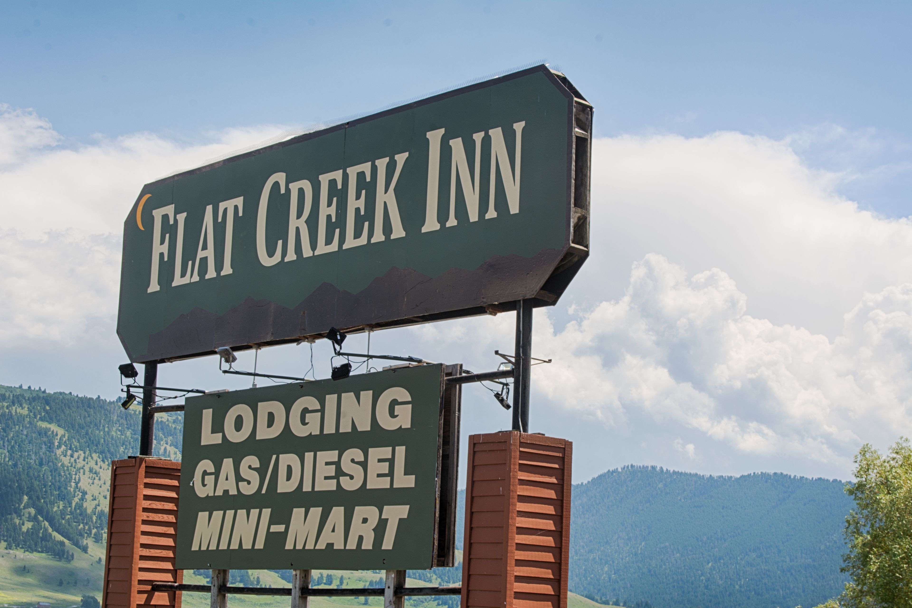 A sign for Flat Creek Inn, indicating it is a lodging with gas/diesel mini-mart.