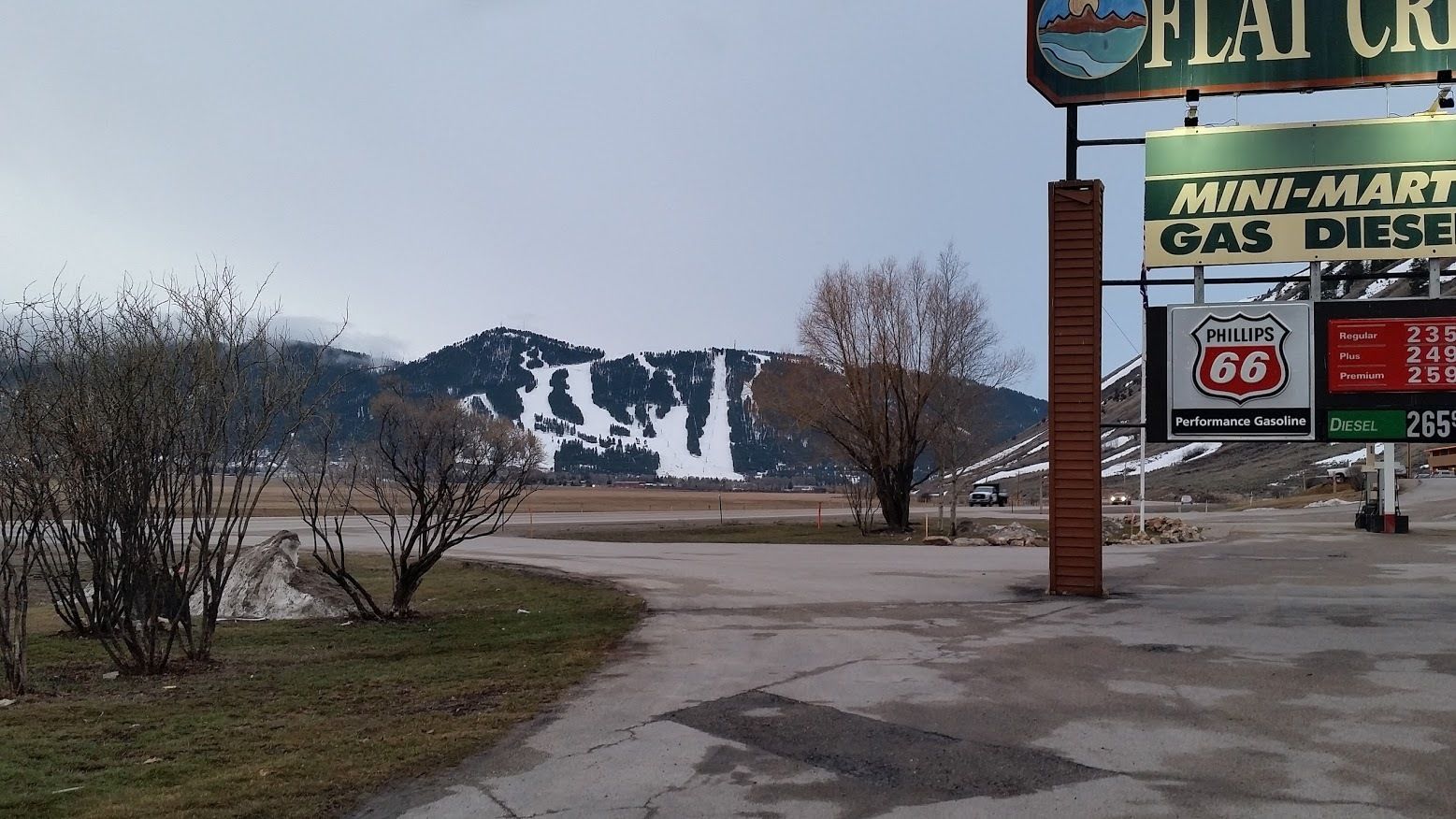Una estación de servicio con una montaña al fondo.
