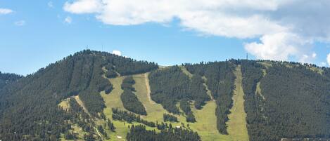 A mountain landscape with a ski resort, including ski slopes and buildings.