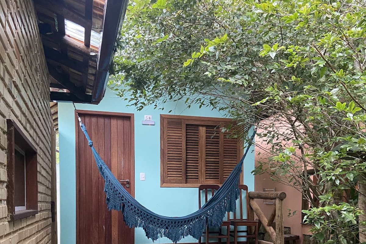 A wooden deck with a hammock, a wooden door, and a small porch area.