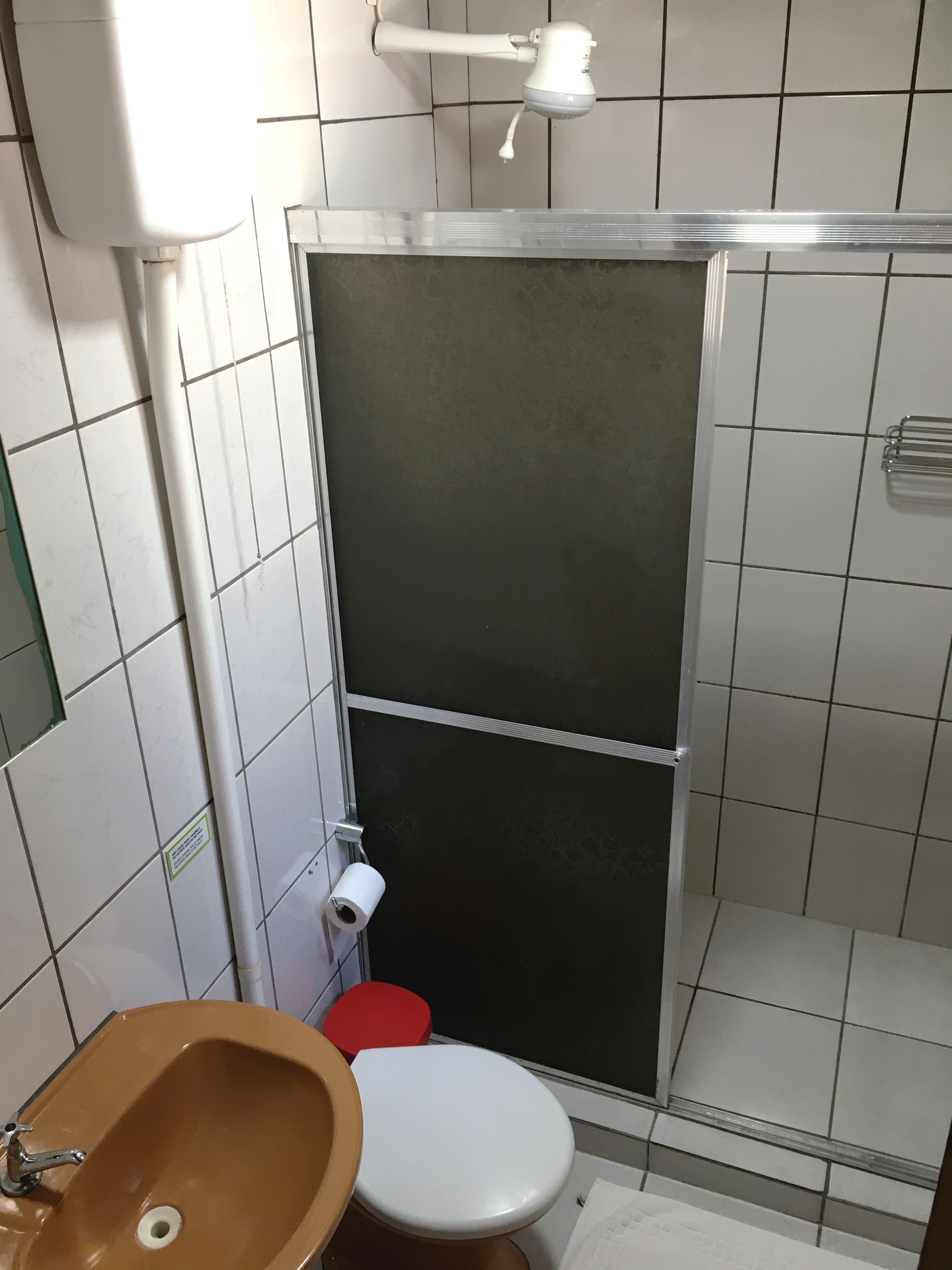 Un baño con inodoro, lavamanos y cabina de ducha.
