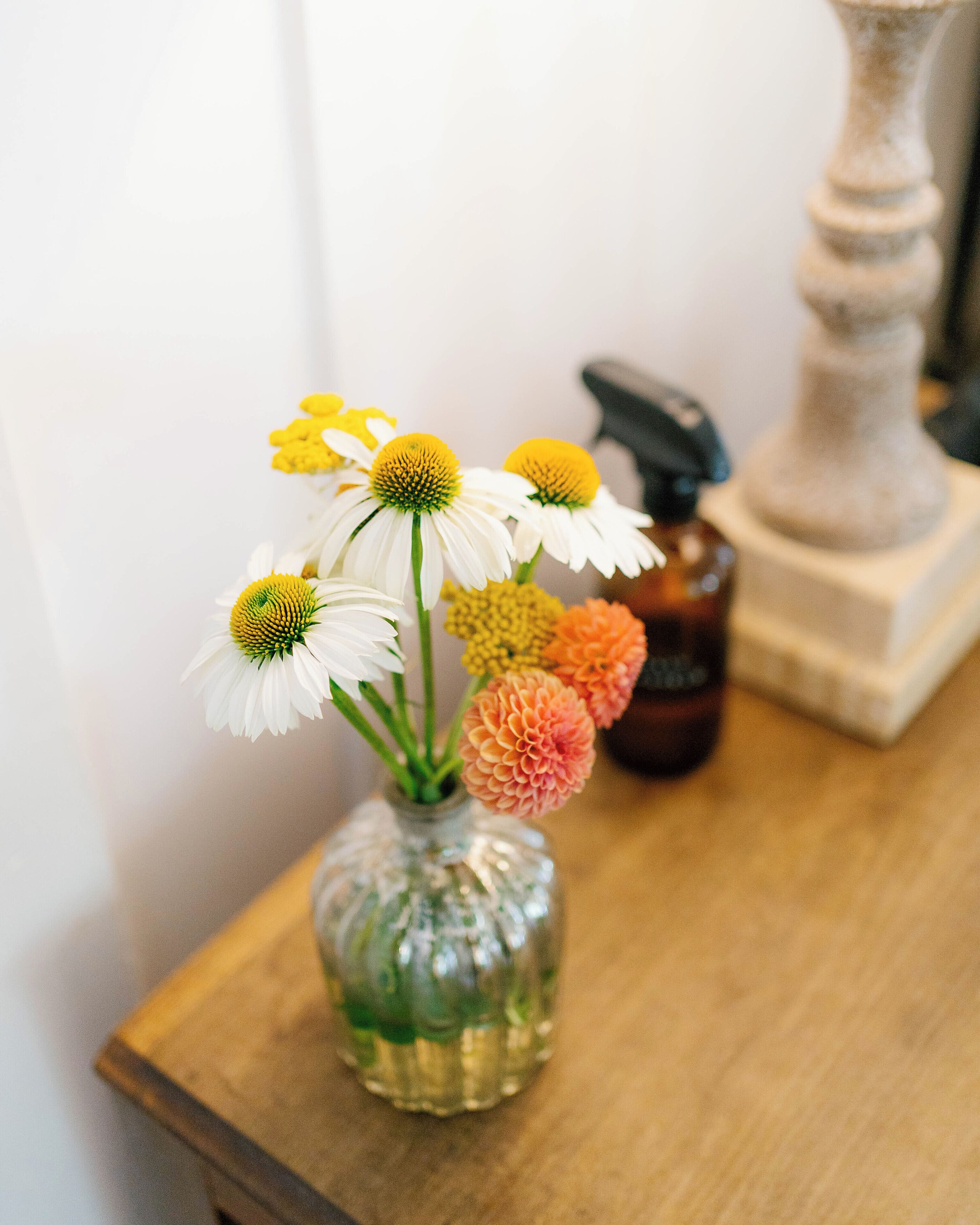 Un vase en verre contenant des fleurs, posé sur une table en bois.