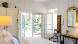 Une chambre à coucher avec un lit, un bureau, une chaise et un grand miroir.