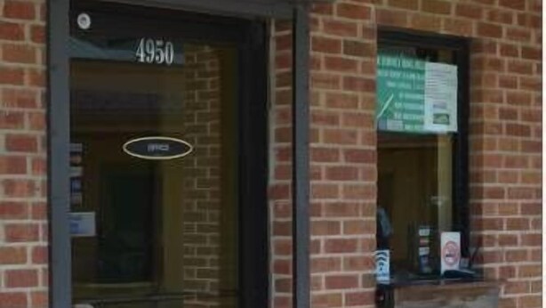 A brick building with a black door labeled "4950". - Royal Inn of New Orleans (New Orleans)