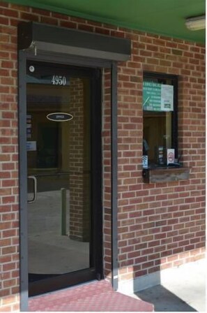 A brick building with a black door labeled "4950". - Royal Inn of New Orleans (New Orleans)