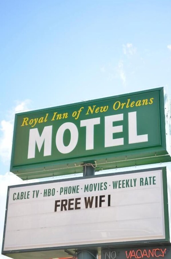 A motel sign with amenities including cable TV, HBO, phone, movies, and free WiFi.