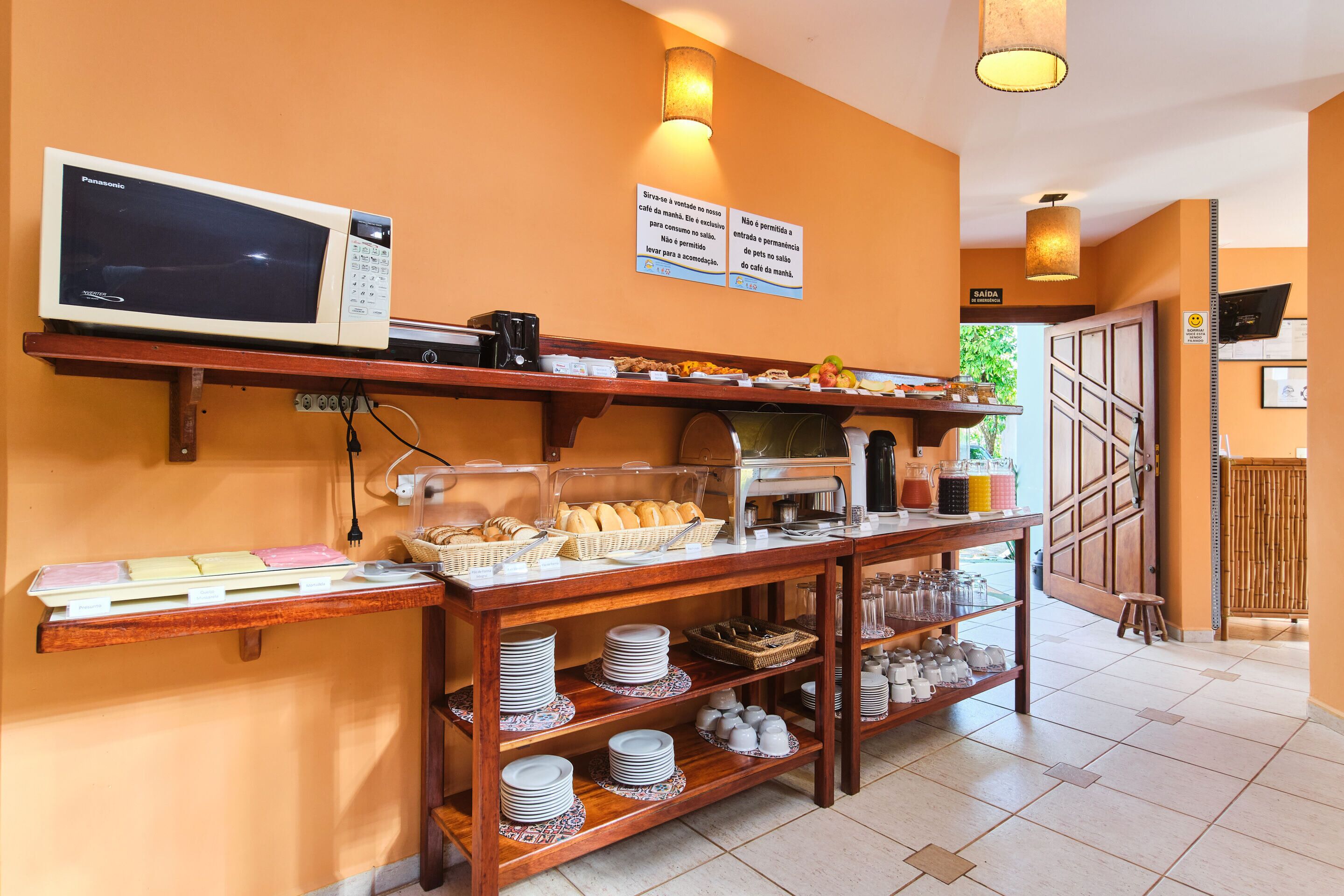 Zona de desayuno tipo buffet con microondas, pan, bollería y diversas opciones para el desayuno.