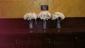 Letrero de DeSimone's Steakhouse con tres jarrones de flores debajo.
