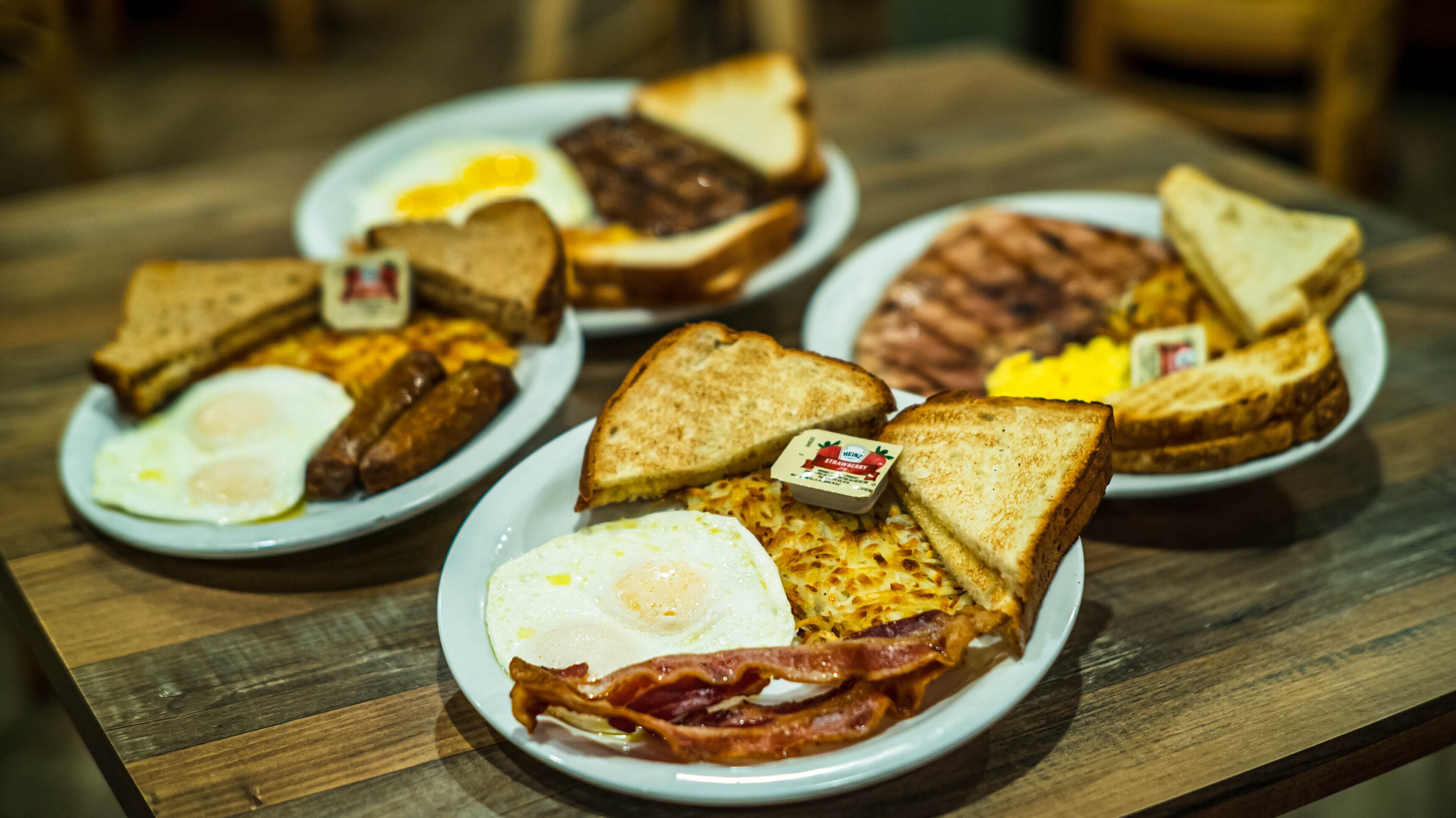 A breakfast plate with eggs, bacon, toast, and sausages.