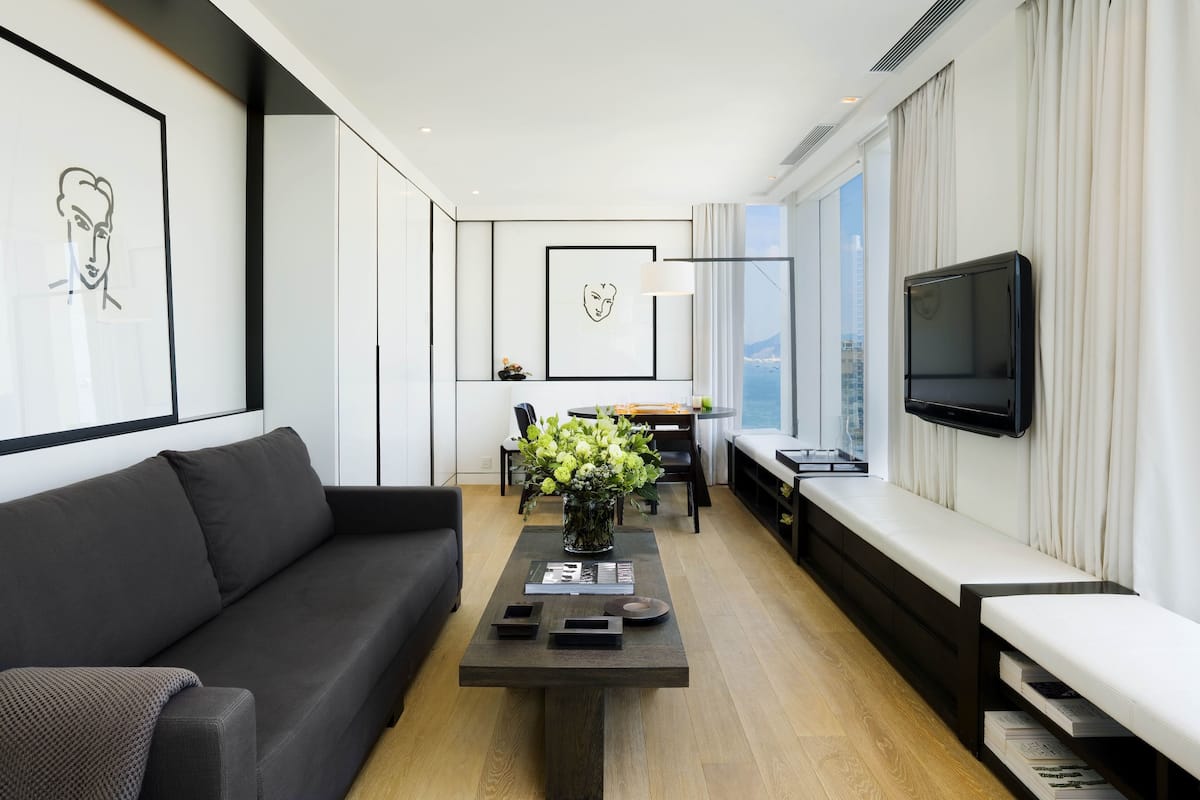Un salon moderne avec un canapé, une table basse et un téléviseur fixé au mur.