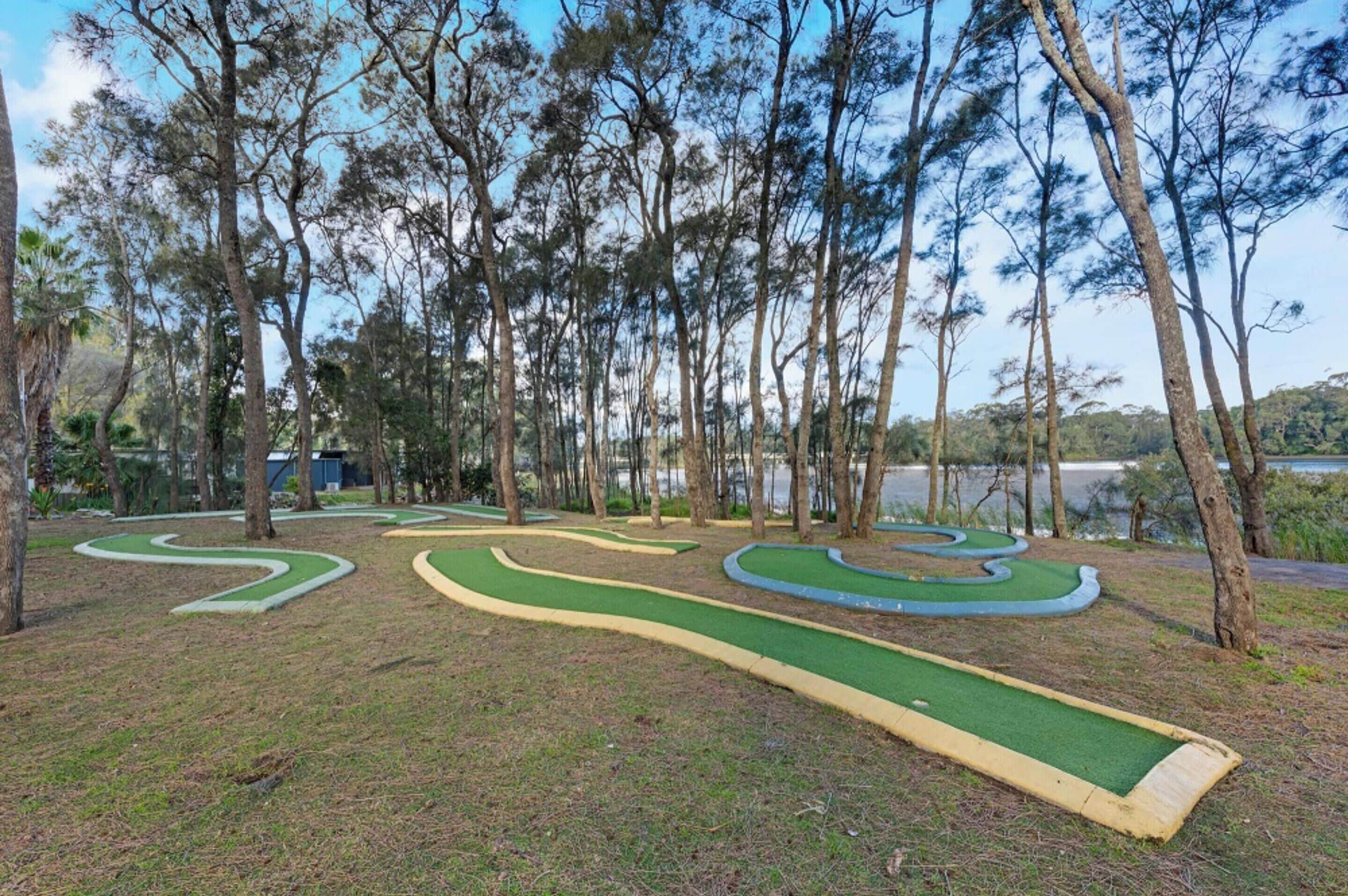 Un campo de golf con senderos sinuosos y un lago al fondo.