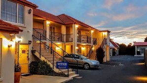 Ein mehrstöckiges Motel, mit einem Schild, das einen Empfangsbereich im Erdgeschoss kennzeichnet.