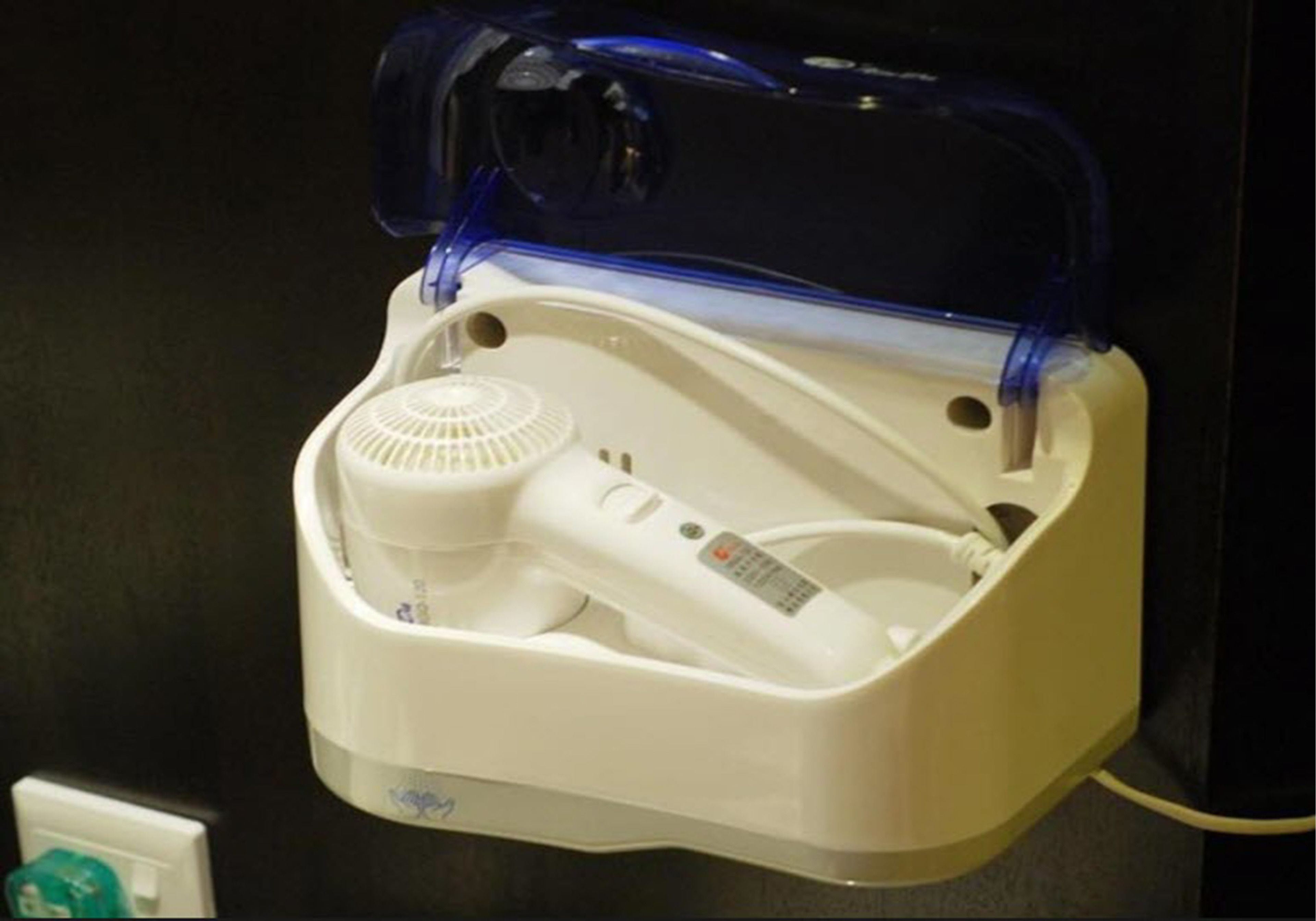 A white portable heater with a blue plastic cover, a power cord, and a control panel.