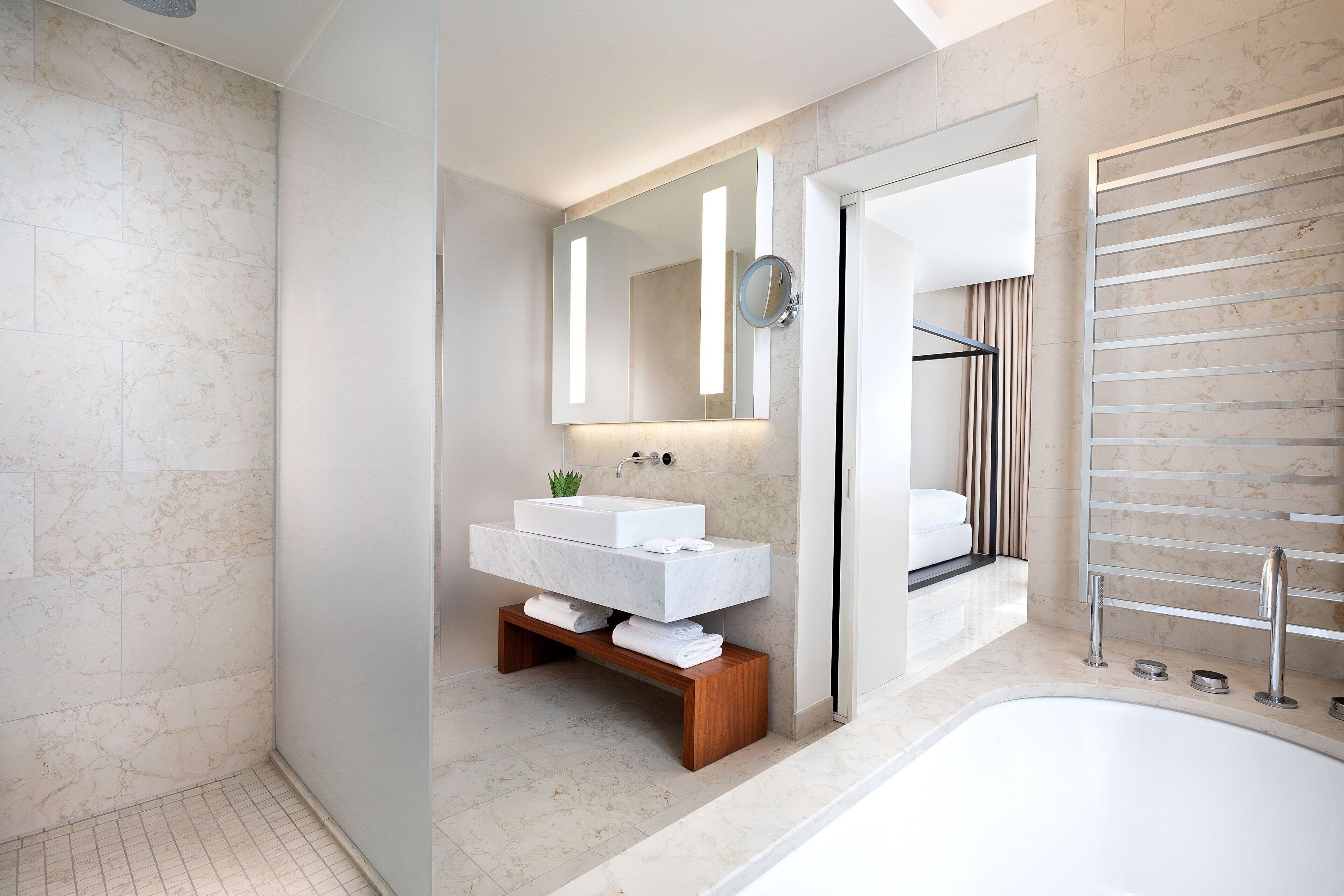 Un baño moderno con un lavamanos grande de color blanco, un espejo y un perchero empotrado.