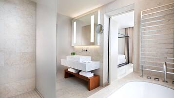 Un baño moderno con un lavamanos grande de color blanco, un espejo y un perchero empotrado.