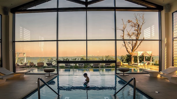 A pool with a view of the sunset and distant buildings. - JW Marriott Venice Resort & Spa (Venice)