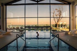 Ein Pool mit Blick auf den Sonnenuntergang und entfernte Gebäude.