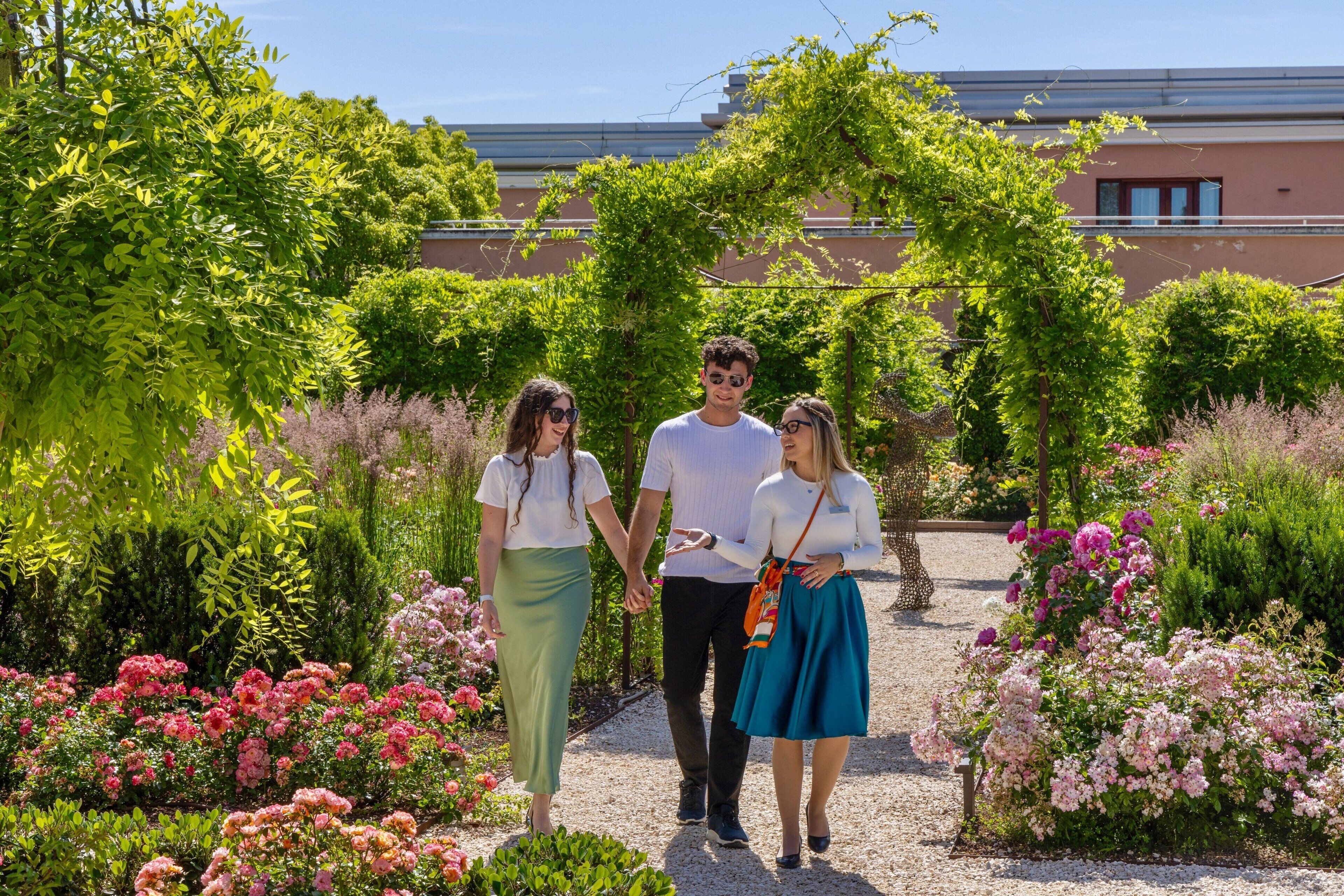A garden pathway with lush greenery and flowering plants.