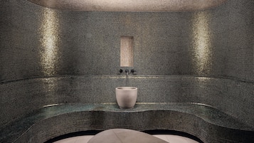 A modern, tiled room with a central seating area and a rectangular mirror on the wall.