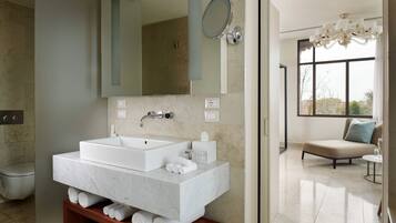 Un baño moderno con un lavamanos grande, un espejo y un perchero para toallas.