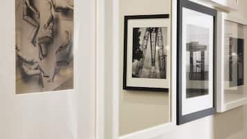 A wall with framed artworks, including a sculpture and a photograph of a structure.