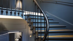 A staircase with black balusters and wooden steps. - Hôtel Le Marianne (Paris)