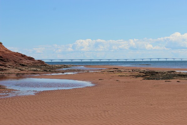 A beach with a bridge in the background. - Cottages on PEI (Chelton)