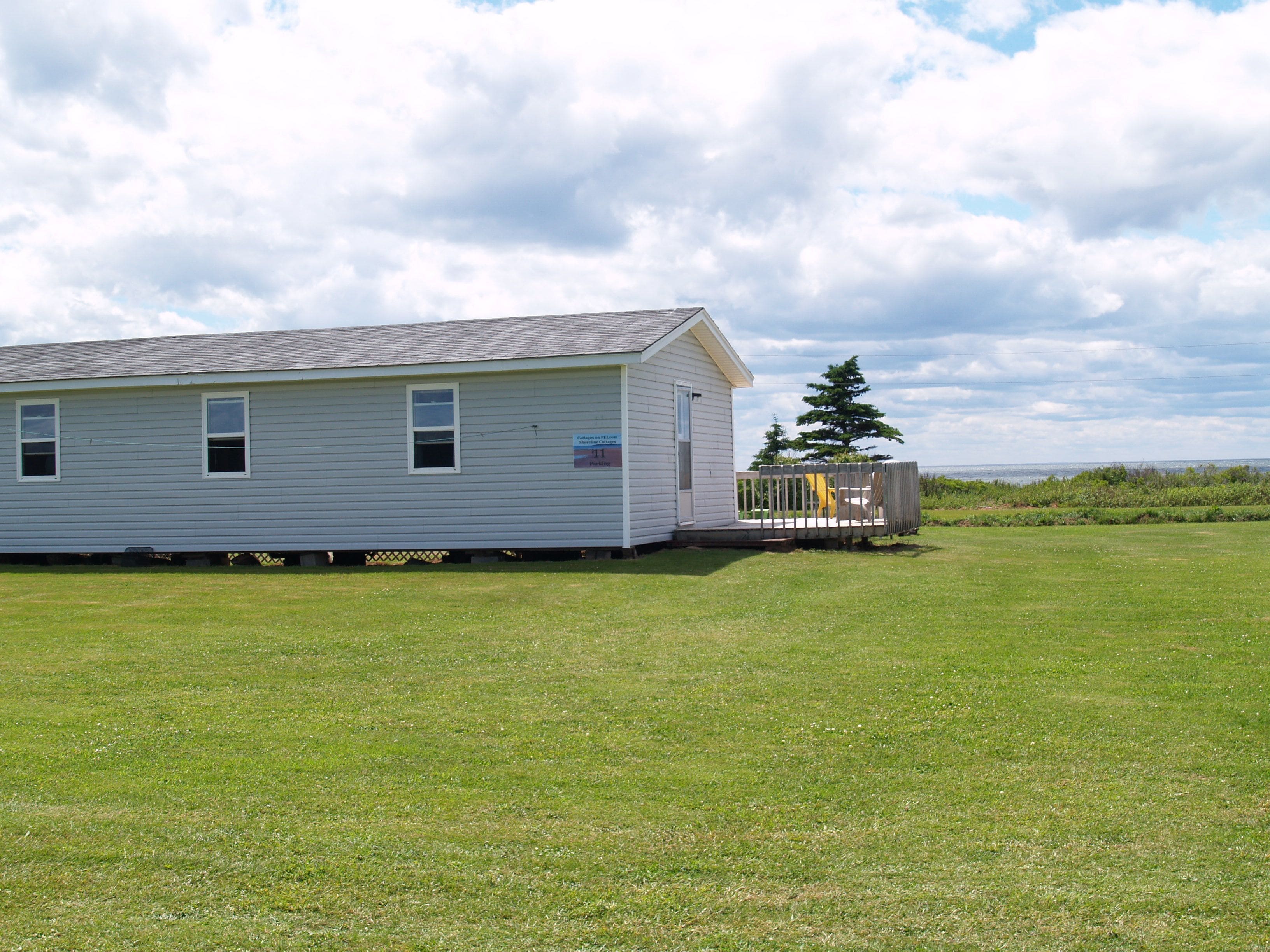 A single-story, light-colored building with a small porch and a sign indicating it is a campground.
