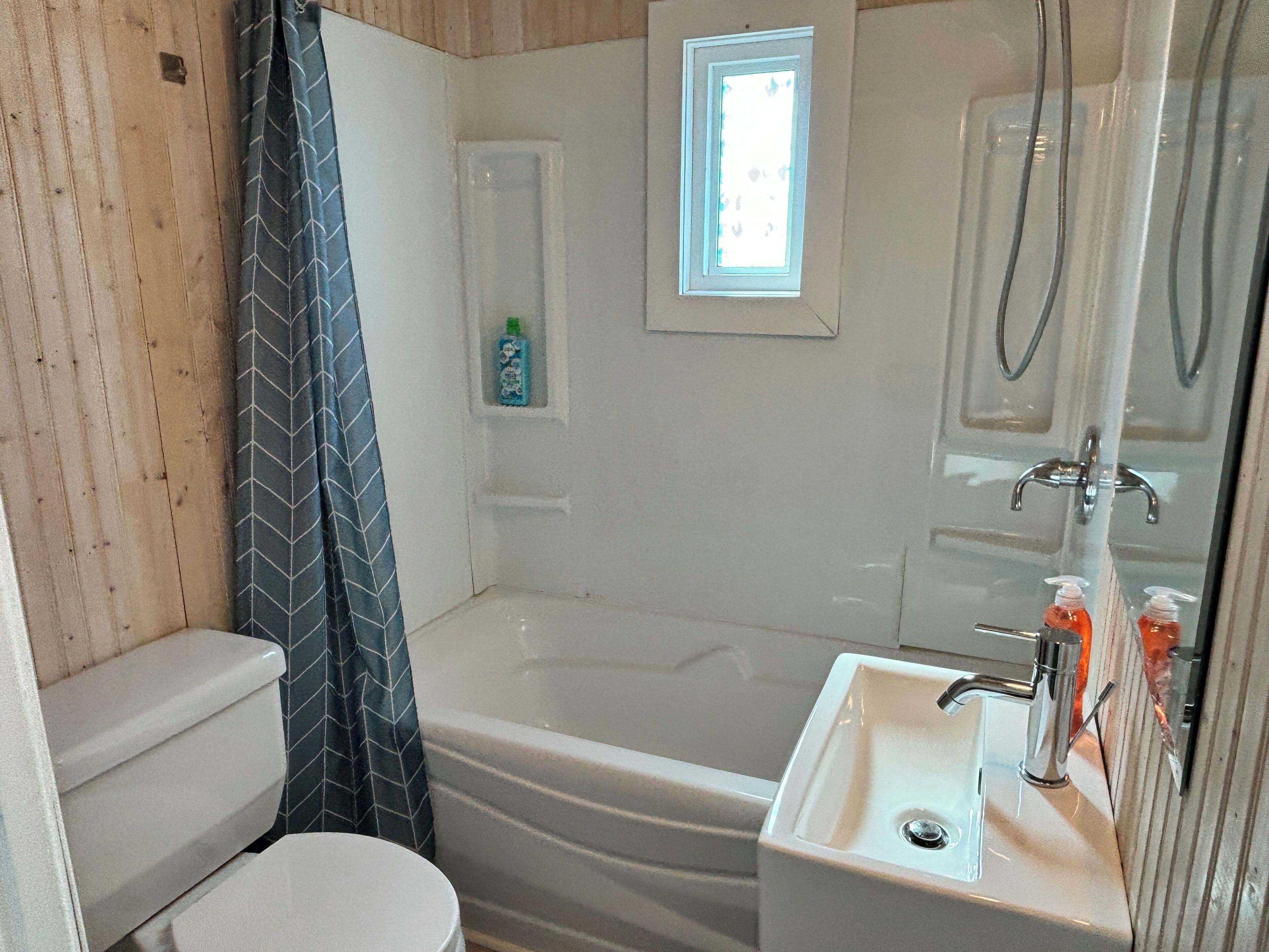 A bathroom with a bathtub, a toilet, a sink, and a shower curtain.