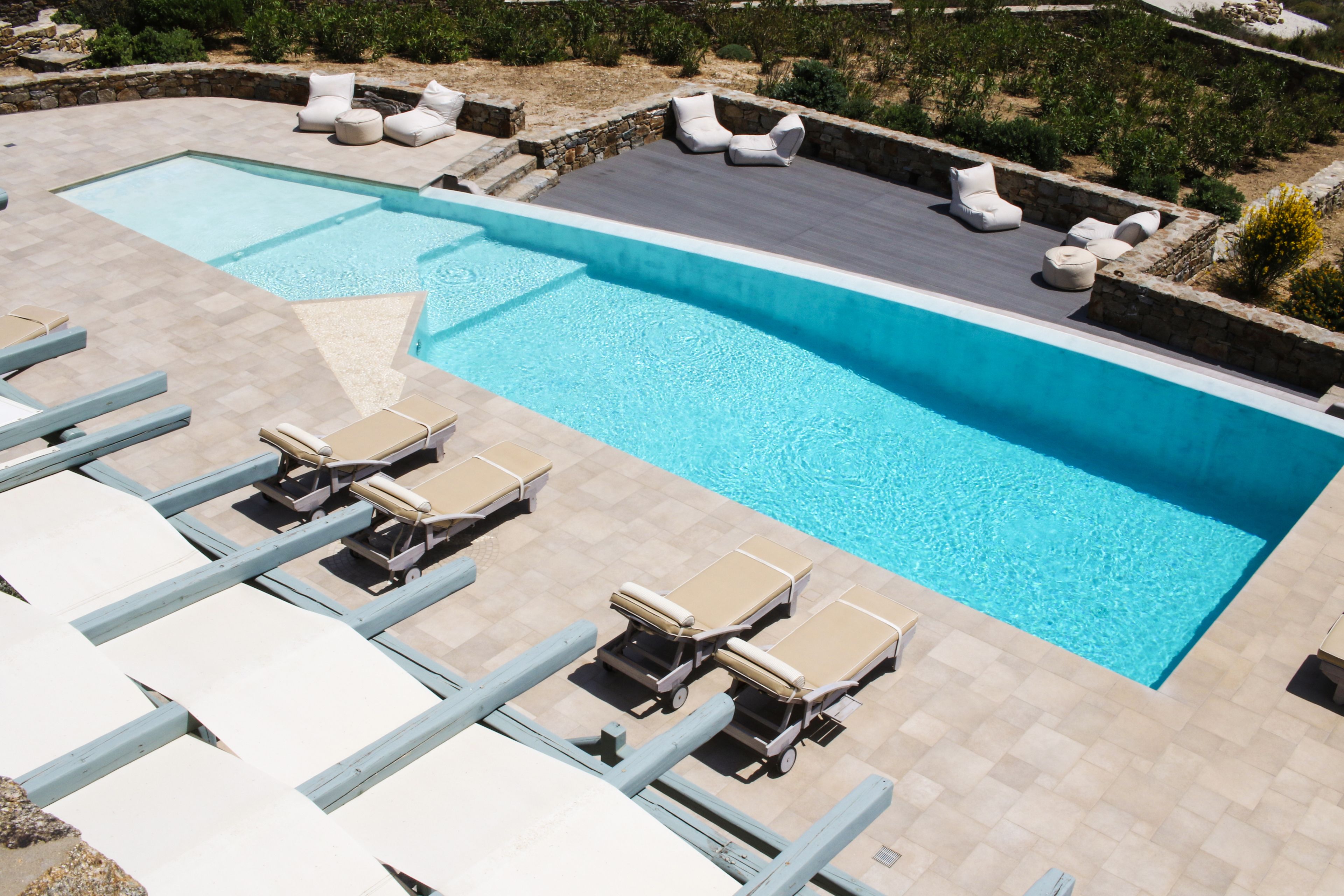 A swimming pool with lounge chairs and a deck area.