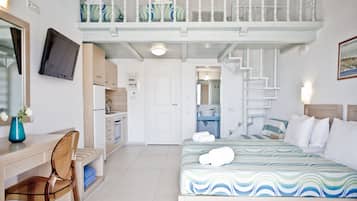 A hotel room with a bed, a desk, a chair, a TV, a balcony, and a bathroom.