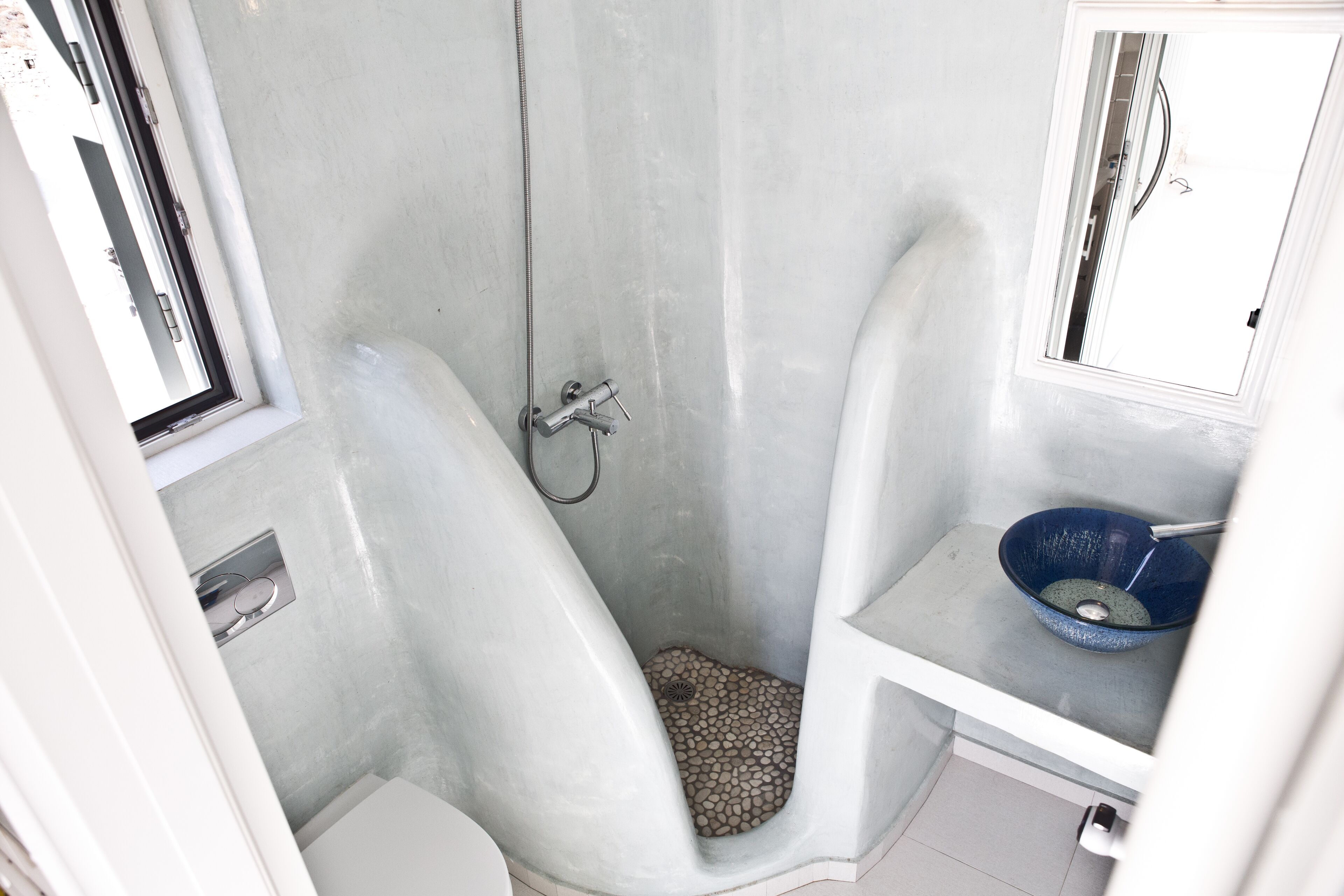 A bathroom with a shower, a sink, and a mirror.