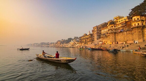 Un río tranquilo con barcos, una orilla con edificios y un cielo despejado.