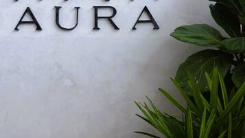 A wall-mounted sign with the word "AURA" and a stylized design above it.